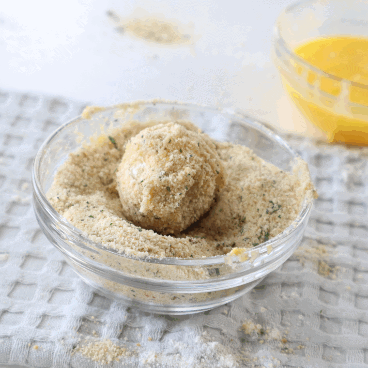 Three shallow bowls with flour, eggs, and breadcrumbs for coating cheese bites.