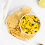 Bowl of vibrant mango salsa with diced mango, red bell pepper, jalapeño, and fresh herbs.