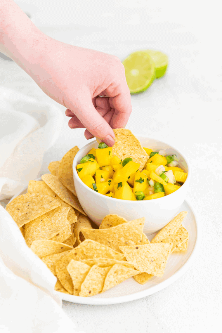 Bowl of colorful mango salsa with diced mango, red bell pepper, jalapeño, and fresh herbs.