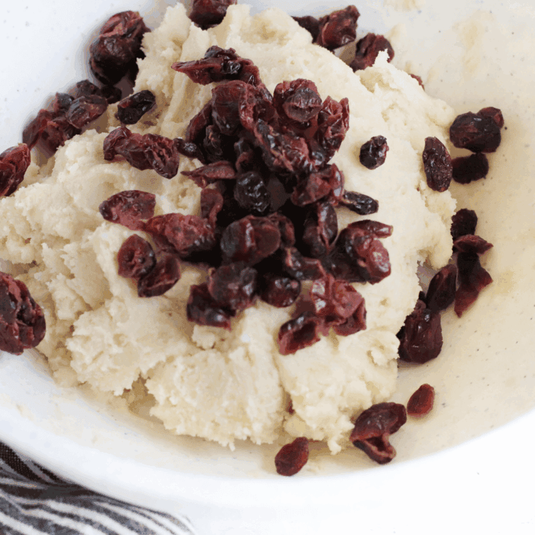Folding in dried cranberries and white chocolate chips evenly throughout cookie dough.