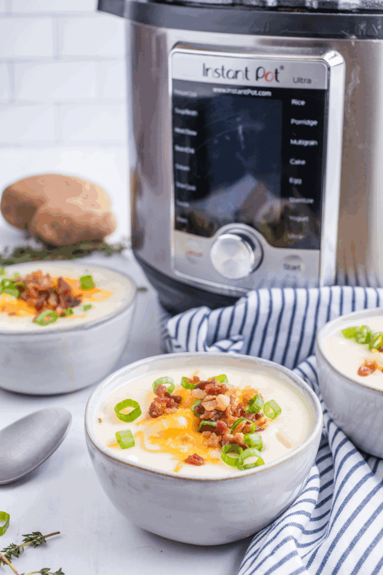 Bowl of creamy Copycat La Madeleine Country Potato Soup garnished with fresh herbs.