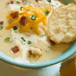 Bowl of creamy Copycat La Madeleine Country Potato Soup garnished with herbs.