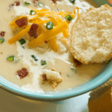 Bowl of creamy Copycat La Madeleine Country Potato Soup garnished with herbs.
