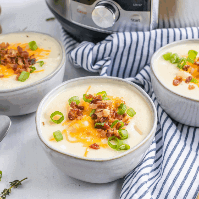 Bowl of creamy Copycat La Madeleine Country Potato Soup garnished with herbs.