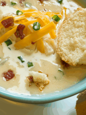 Bowl of creamy Copycat La Madeleine Country Potato Soup garnished with herbs.