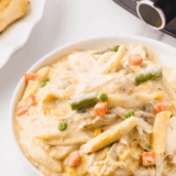 Creamy Crock Pot Chicken Pot Pie Pasta with chicken, peas, carrots, and noodles in a rich sauce.