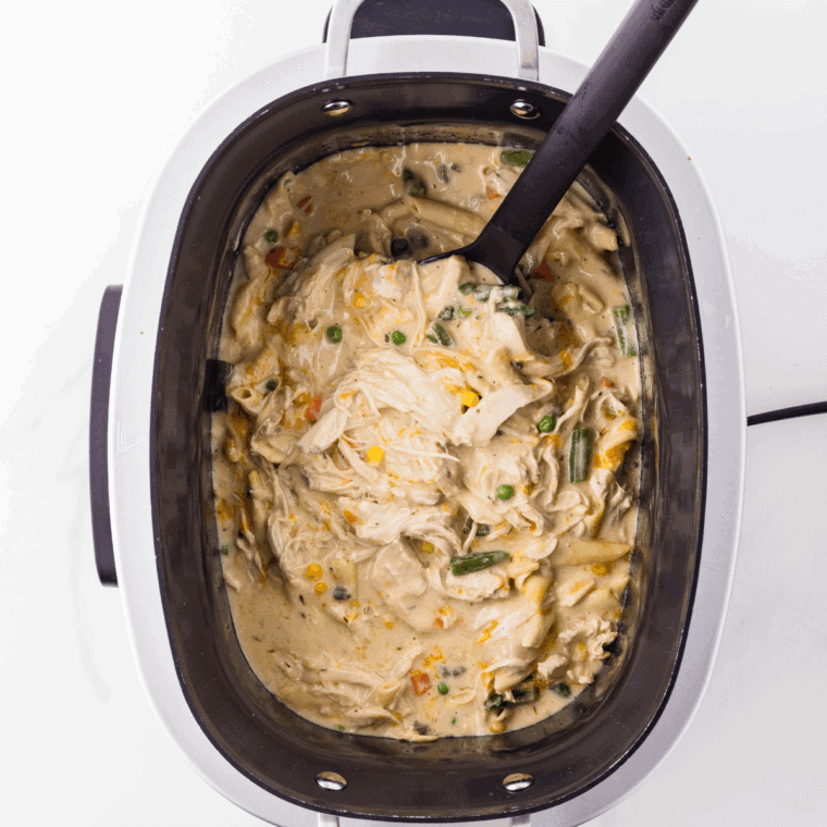 Creamy Crock Pot Chicken Pot Pie Pasta with shredded chicken, rotini, mixed vegetables, and melted cheese.