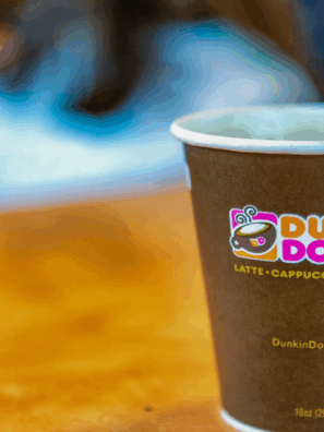 Assorted Dunkin’ drinks without coffee, including hot chocolate, Coolattas, and iced tea, served in colorful cups.