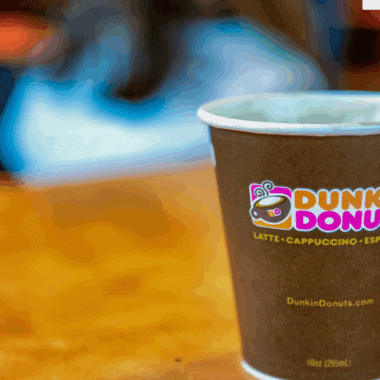 Assorted Dunkin’ drinks without coffee, including hot chocolate, Coolattas, and iced tea, served in colorful cups.