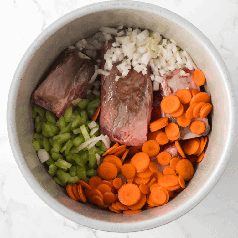 Searing lamb shanks in a Dutch oven until golden brown, set aside.