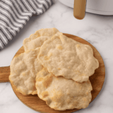 Stack of freshly made air fryer homemade flour tortillas on a plate ready for tacos or burritos.
