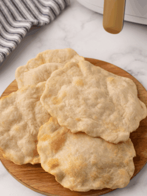 Stack of freshly made air fryer homemade flour tortillas on a plate, ready for tacos or wraps.