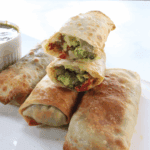 Make BJ’s Avocado Egg Rolls at home! Crispy egg rolls stuffed with creamy avocado, sun-dried tomatoes, and red onion, served with a tangy cilantro-lime dipping sauce.