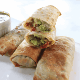 Make BJ's avocado egg rolls at home! Crispy egg rolls are stuffed with creamy avocado, sun-dried tomatoes and red onions and served with a tangy cilantro-lime dipping sauce.