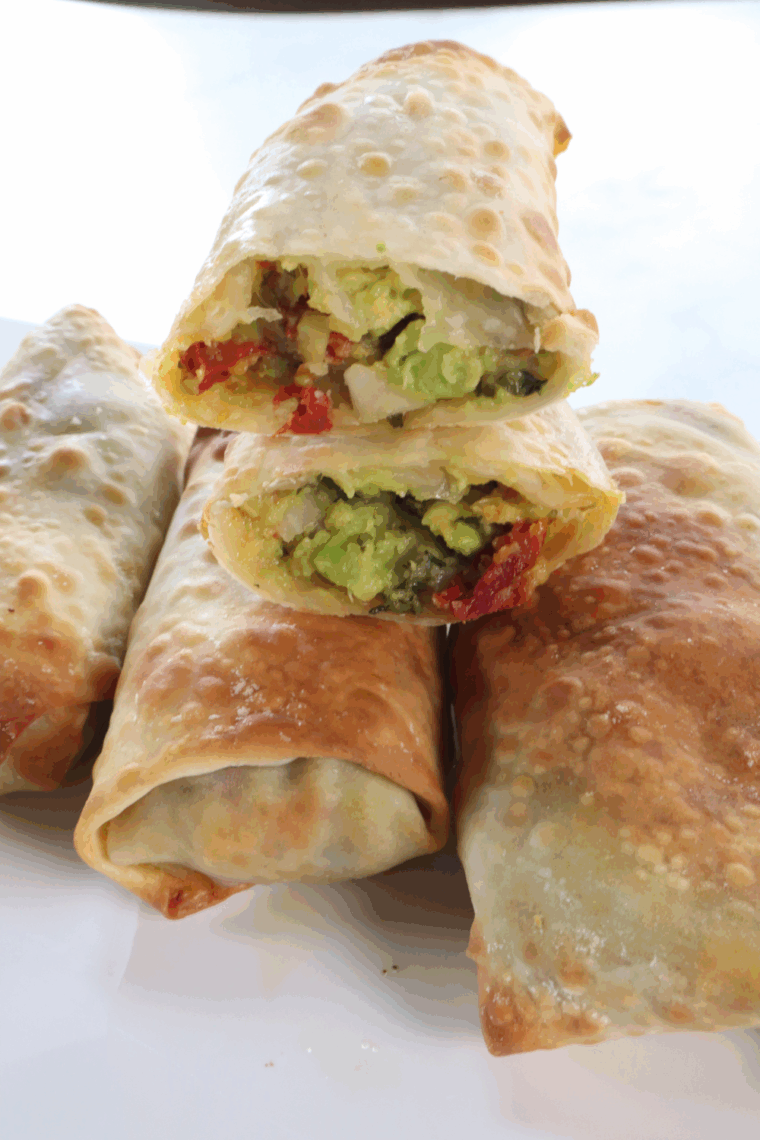 A plate of crispy BJ's avocado egg rolls with creamy cilantro-lime dipping sauce.