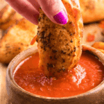 Bowl of easy calzone dipping sauce with herbs and tomato base