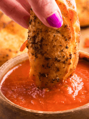 Bowl of easy calzone dipping sauce with herbs and tomato base