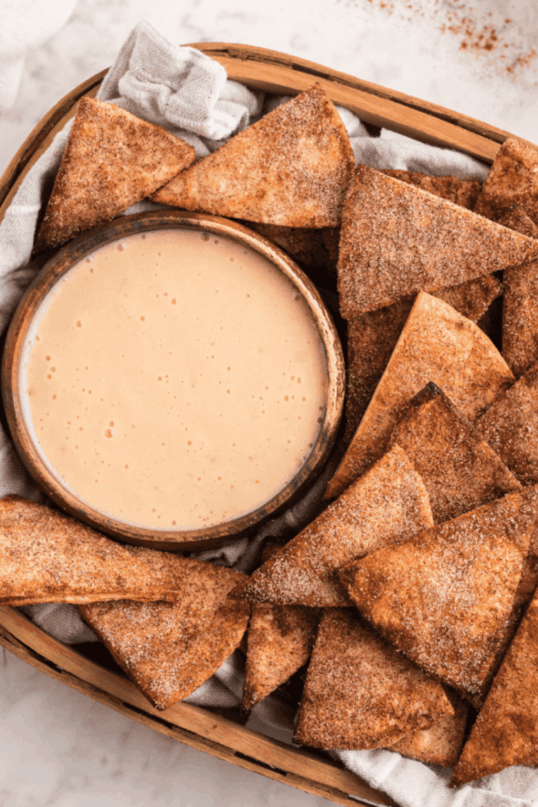 Creamy sweet dip in a bowl with cinnamon sugar pita chips for dipping.