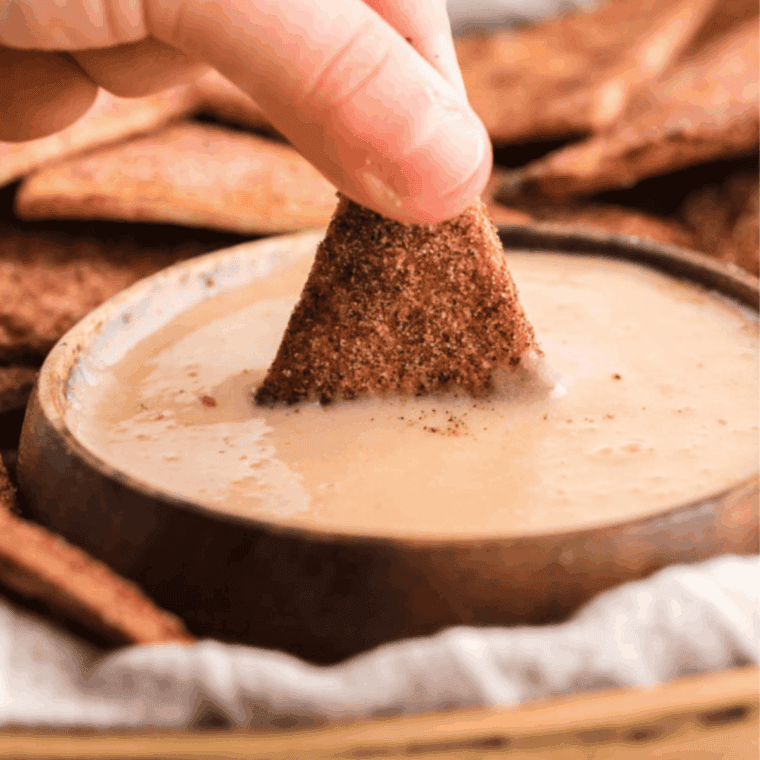 Creamy sweet dip served in a bowl alongside cinnamon sugar pita chips.