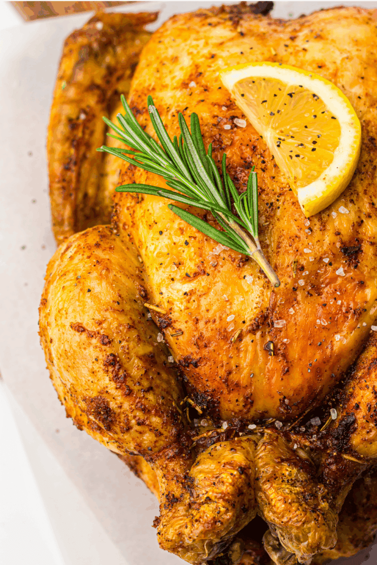 Roasted Ina Garten chicken with golden crispy skin, herbs, and lemon on a serving platter.