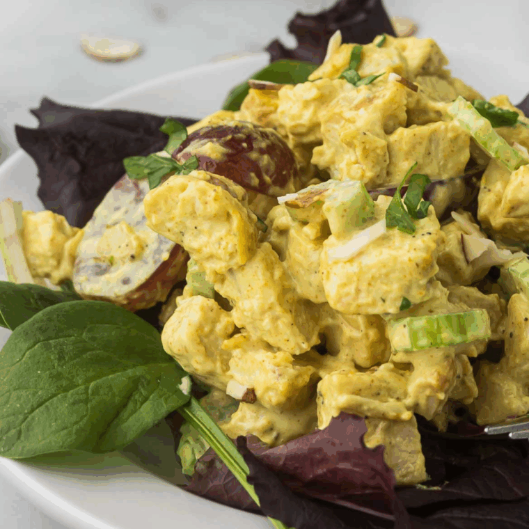 Ina Garten’s curried chicken salad with apples, raisins, celery, and almonds served in a bowl.