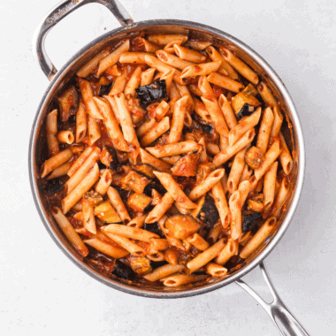 Ina Garten’s homemade marinara sauce simmering in a skillet with fresh herbs and vibrant tomatoes.