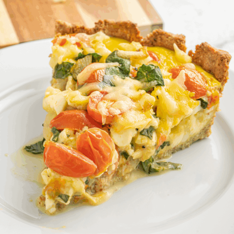 Golden-baked Ina Garten quiche with flaky crust and creamy cheese filling served on a plate.