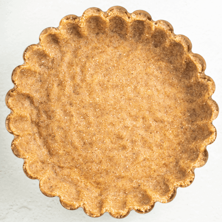 Rolling out pie crust in a 9-inch pan and blind baking until golden.