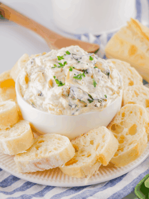 A creamy bowl of Lipton Onion Soup Spinach Dip served with crackers and fresh veggies on a wooden board, ready for a party snack.