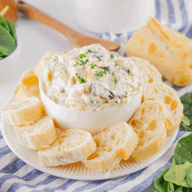 A creamy bowl of Lipton Onion Soup Spinach Dip served with crackers and fresh veggies on a wooden board, ready for a party snack.