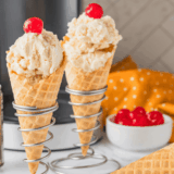 Creamy Butterbeer Ice Cream in a bowl with whipped cream topping