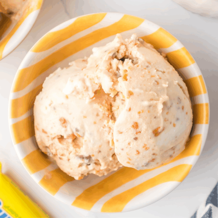 Creamy Ninja Creami Butterfinger Ice Cream topped with crushed Butterfinger pieces in a bowl.