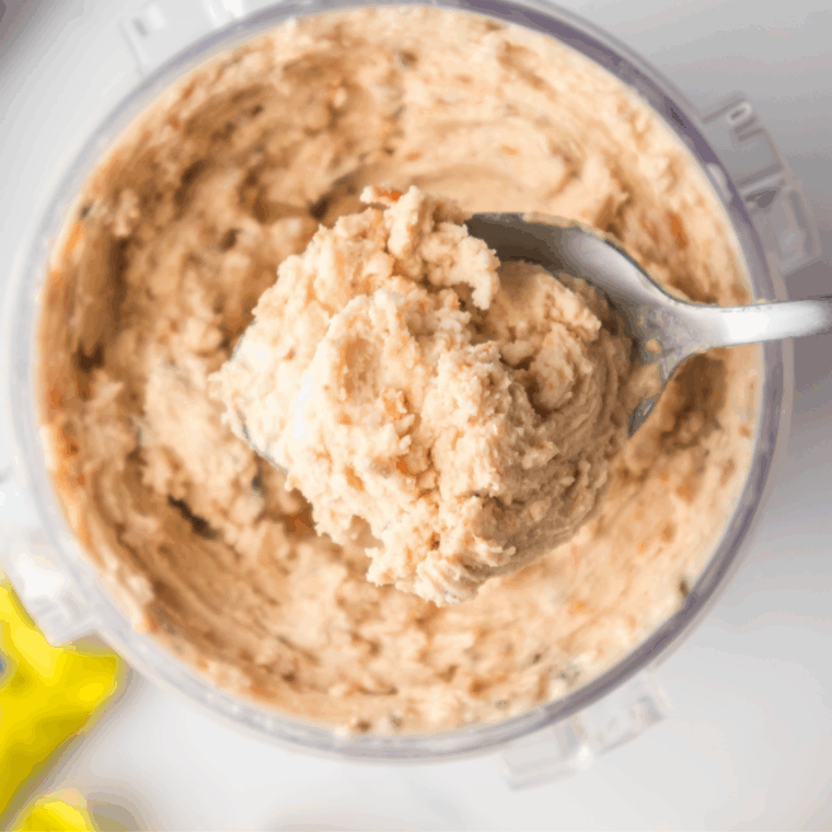 Scooping the finished thick and creamy Butterfinger ice cream into bowls or cones, ready to serve.