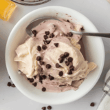 A pint of creamy Ninja Creami cherry chocolate ice cream with chocolate chunks and fresh cherries.