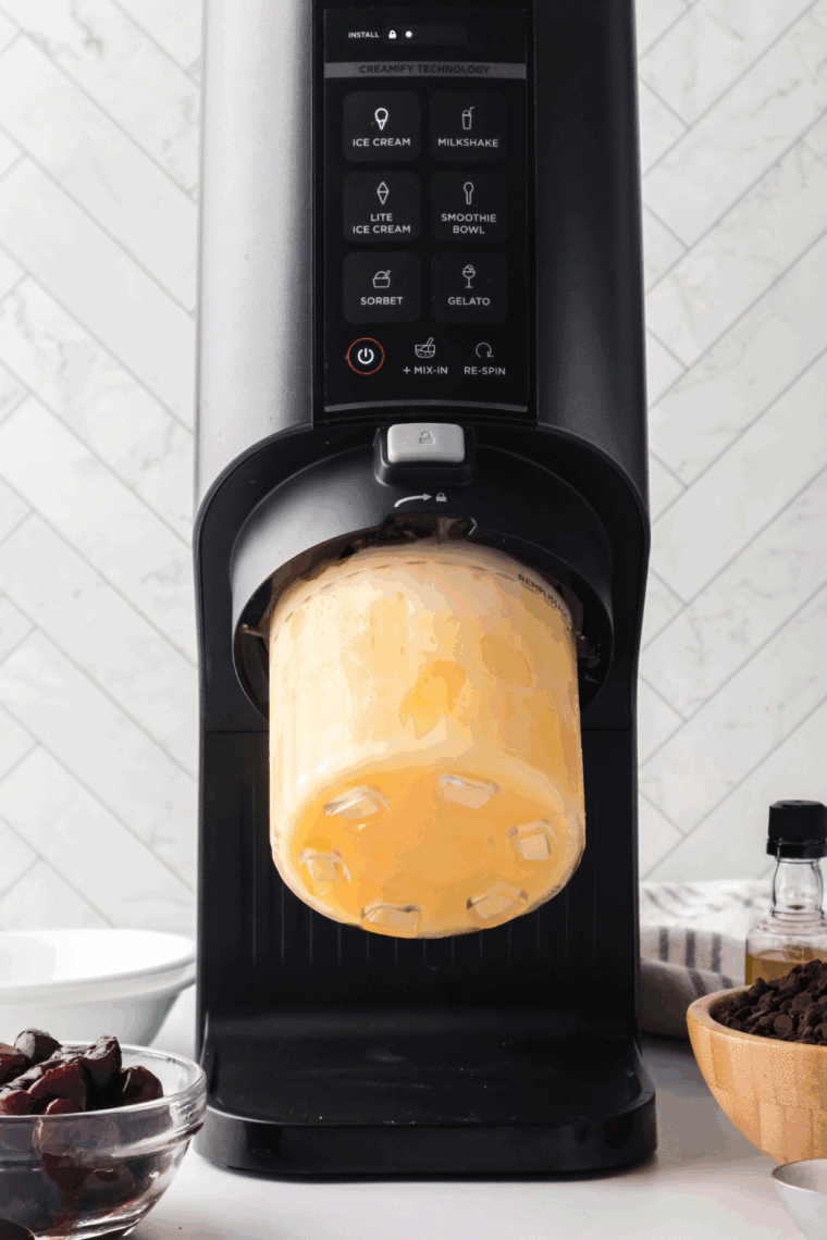 Frozen pint placed into the Ninja Creami machine, churning to create smooth, creamy ice cream.