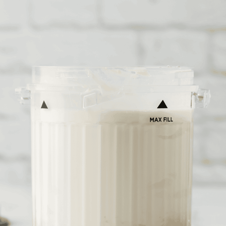 Lemon ice cream mixture poured into a Ninja Creami pint container, ready to freeze for 24 hours.