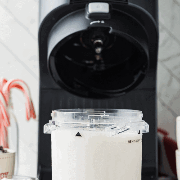 Pint container inserted into Ninja Creami machine with Creamerizer™ Paddle attached.