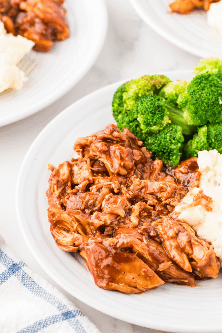 Tender shredded BBQ chicken cooked in the Ninja Foodi and served on a bun with extra barbecue sauce.