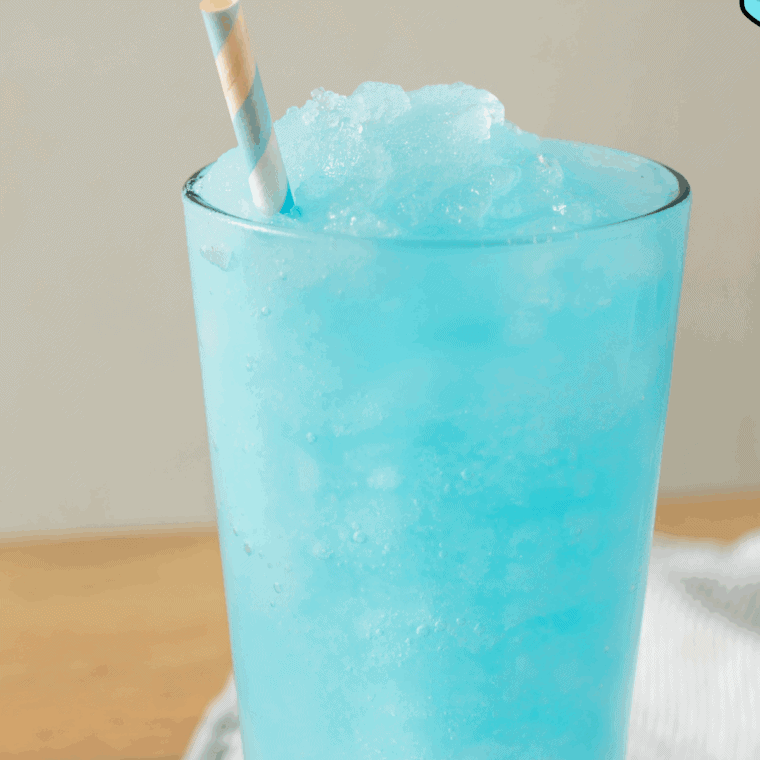 Scooping freshly made blue raspberry slush into glasses, ready to serve and enjoy.