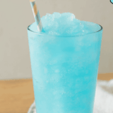 Homemade Ninja Slushi Blue Raspberry Slush in a glass with ice and garnish.