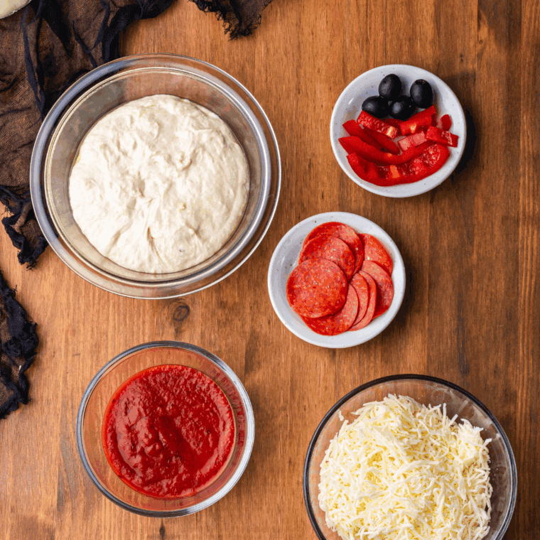 Ingredients needed for Easy Peasy Skull Halloween Pizza on kitchen table.