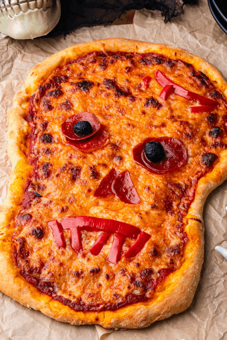 Cooling and slicing the spooky skull pizza, ready to serve for Halloween.