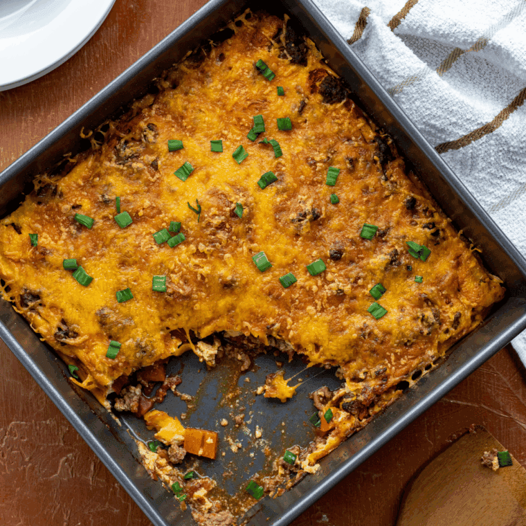 Slice of Pioneer Woman’s Cheeseburger Pie topped with melted cheese and served on a white plate.