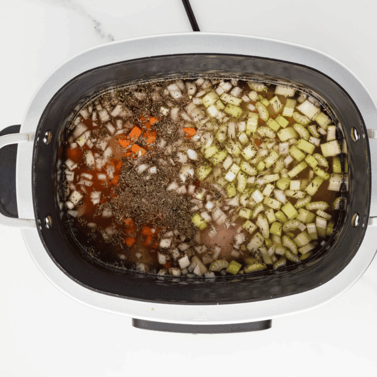 Chopped carrots, celery, onion, and minced garlic ready for slow cooker.