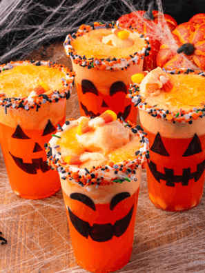 Halloween Jack-O-Lantern Floats made with orange soda and vanilla ice cream, served in pumpkin-themed glasses with festive straws.
