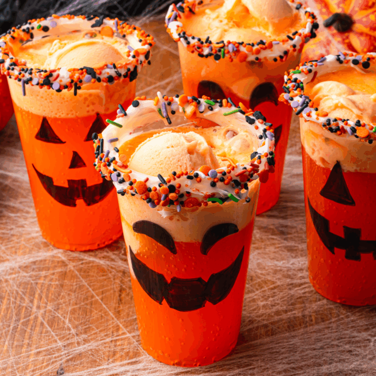 Garnishing Halloween floats with candy corn and pumpkin-shaped marshmallows.
