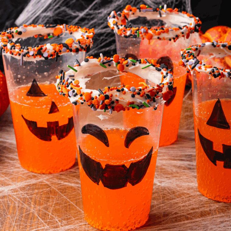 Pouring orange soda into a cup and adding scoops of orange sherbet for a Halloween float.