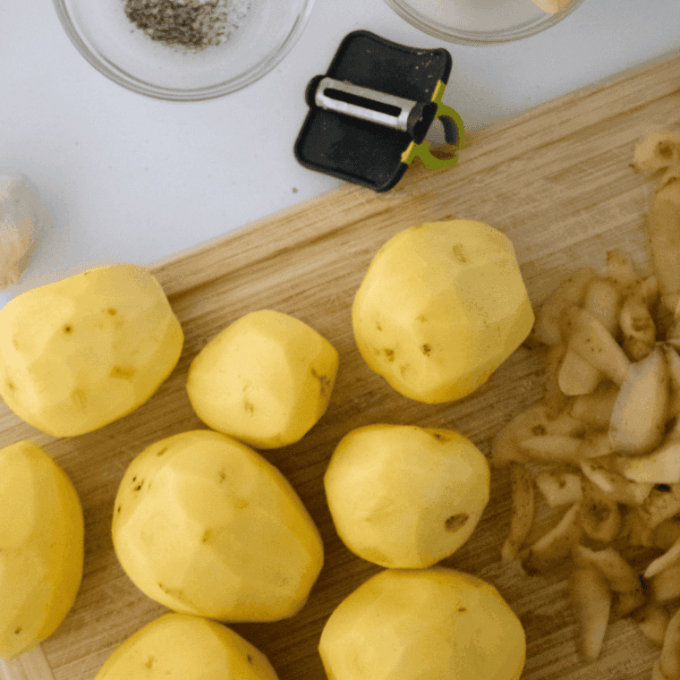Peel the potatoes on a cutting board.