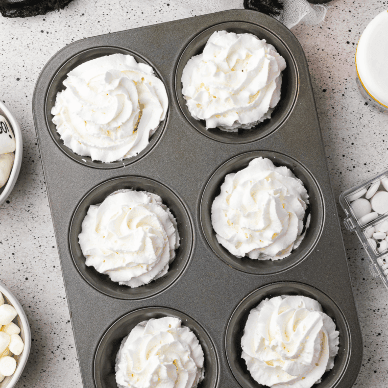 Spoon or pipe fluffy whipped cream into muffin tin, forming small mounds.