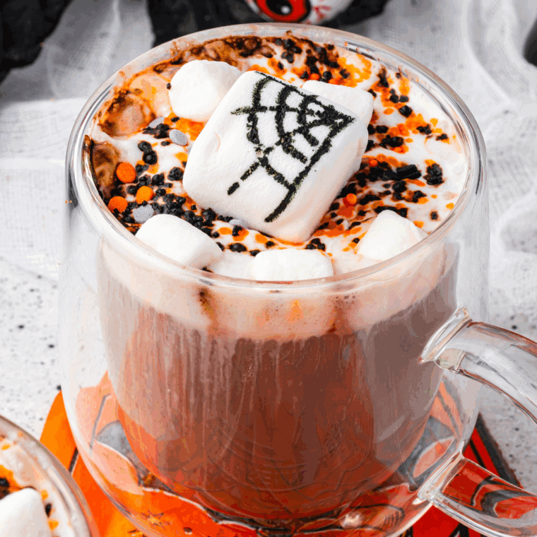 Halloween Hot Cocoa topped with creamy, fluffy whipped cream and festive decorations.